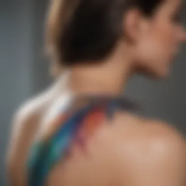 Colorful watercolor feather tattoo on a model's shoulder