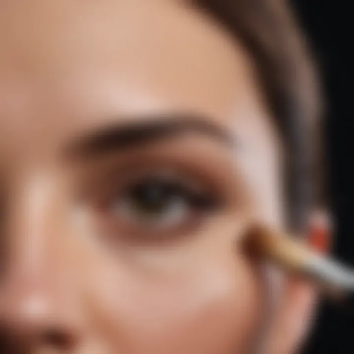 Close-up of a brush applying concealer on skin